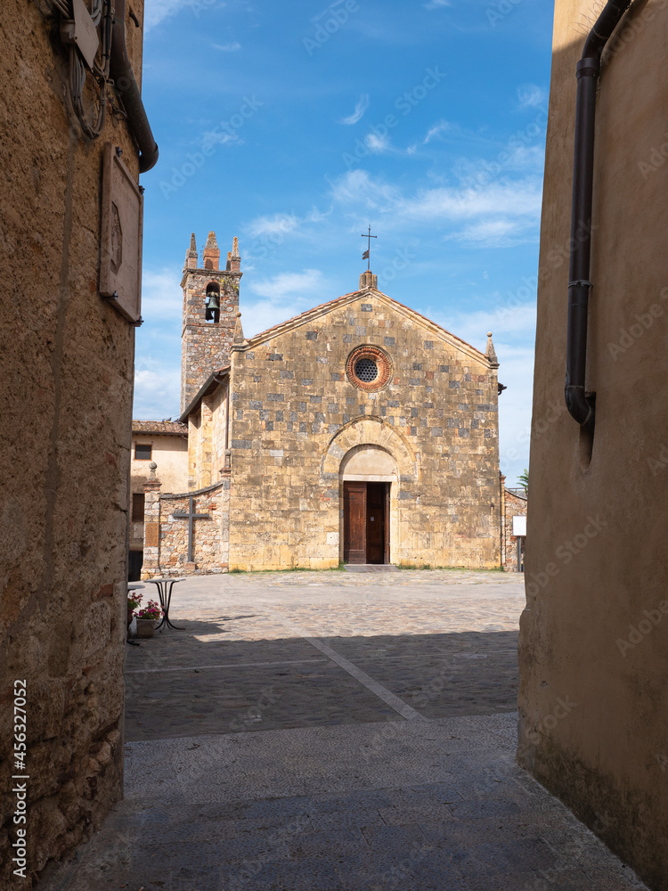 Fototapeta premium View from a Narrow Street in front of the Bell tower and the Church of Santa Maria Assunta in Piazza Roma in Monteriggioni, Siena - Italy