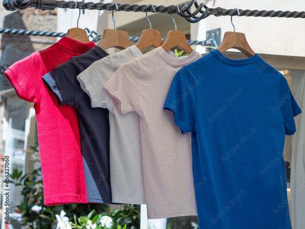 Group of Coloured T-shirts for Children Hanging outside of a Clothing Store