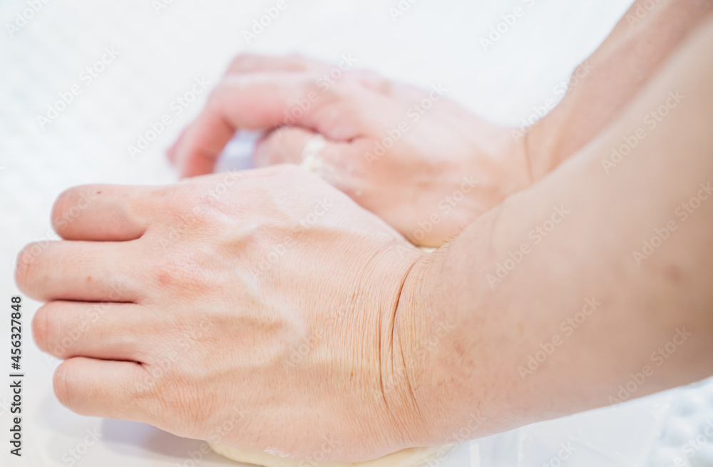 Fototapeta premium 生地をこねる人の写真。パン・ピザ作りのイメージ。