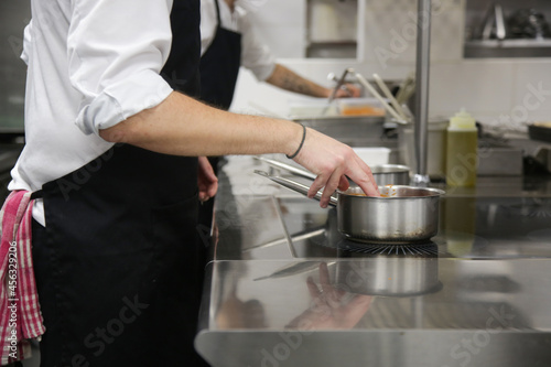 Busy restaurant kitchen. Chef and cooks preparing dishes.