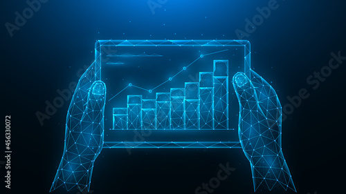 Hands hold a tablet with a graph of increase. Analyzing of financial statistics.