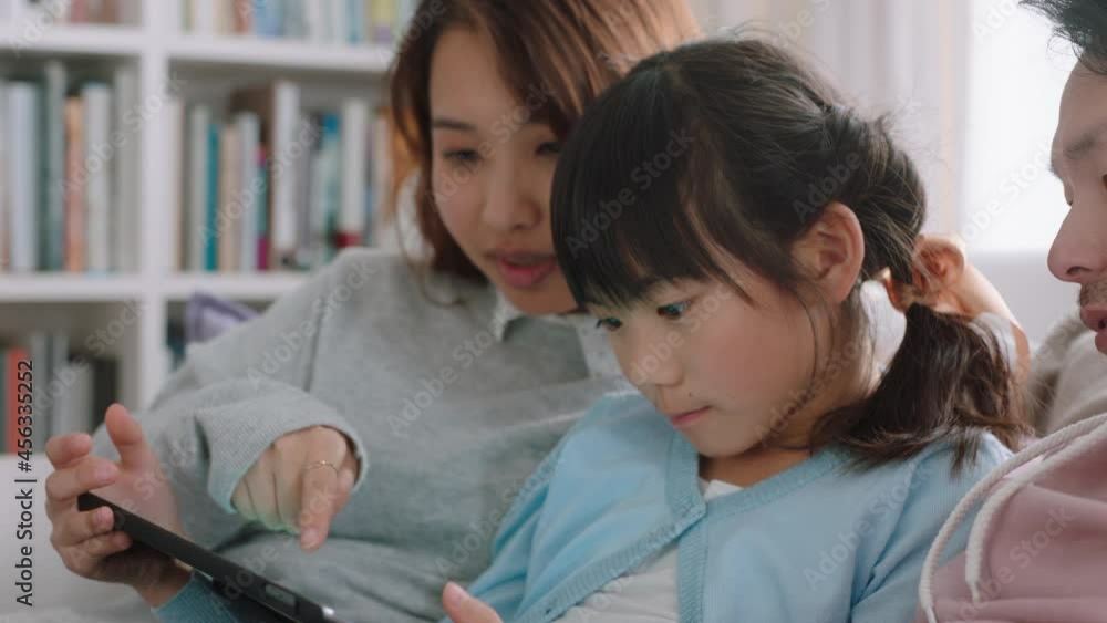happy asian family using tablet computer little girl watching entertainment with parents playing game on touchscreen device browsing online relaxing on sofa together at home 4k footage happy asian family using tablet computer little girl watching entertainment with parents playing game on touchscreen device browsing online relaxing on sofa together at home 4k footage