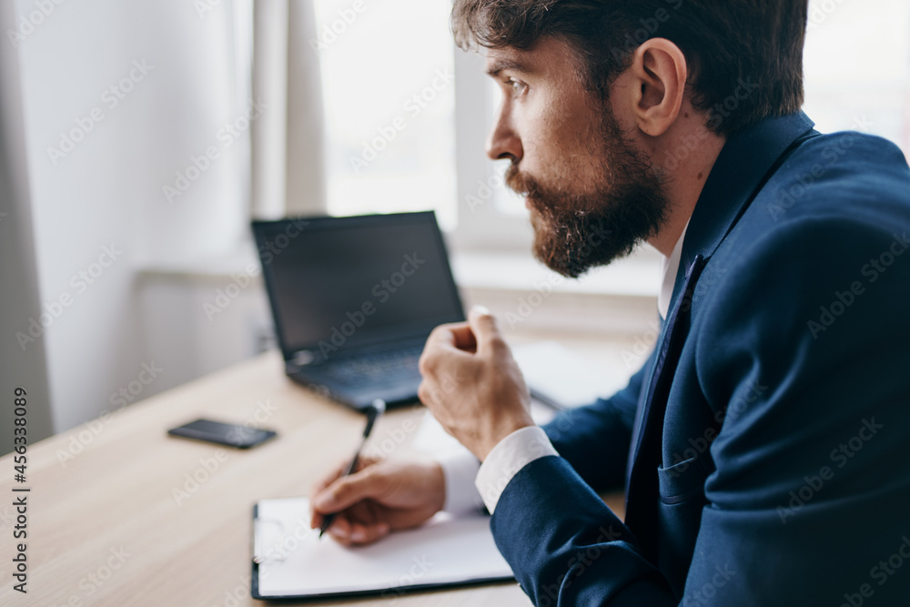 bearded man sitting at a desk in front of a laptop finance technologies bearded man sitting at a desk in front of a laptop finance technologies