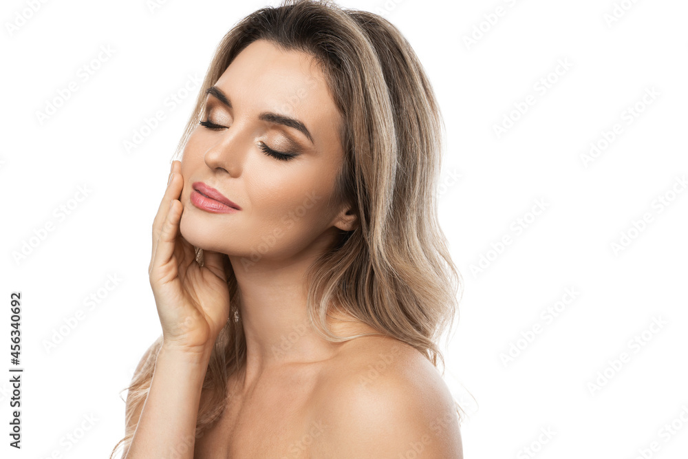 Beautiful blond woman with long wavy hair and smooth skin against white background Beautiful blond woman with long wavy hair and smooth skin against white background