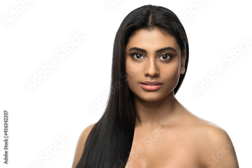 Indian woman with smooth skin and long black hair on white background