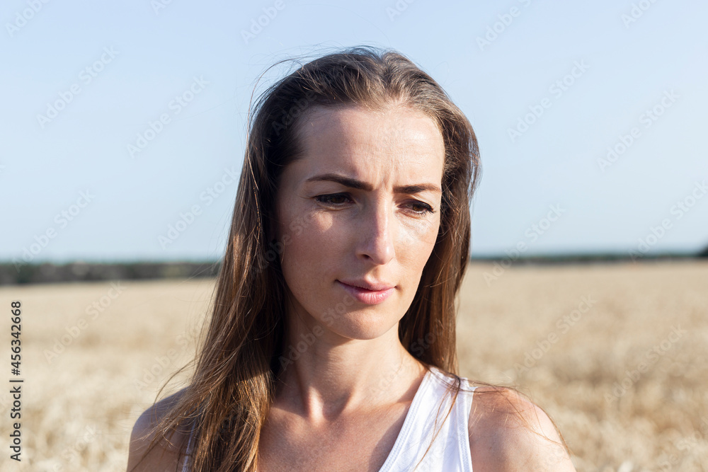 Young woman on a sunny day in a wheat field