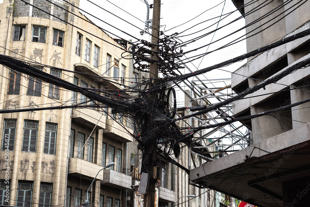 Tangle of Electrical cables and communication wires on electric pole.