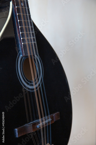 Black Irish bouzouki close up. Light background.