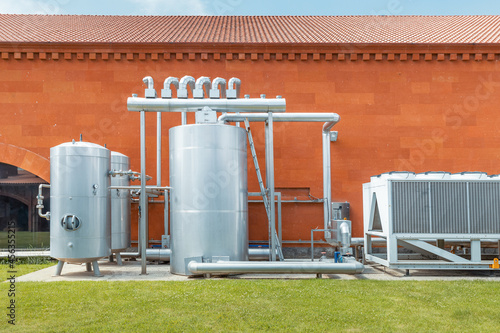 Industrial refrigeration system with compressor and metal tanks outside the wine production plant. Thermovinification and temperature constancy in the cellar. photo