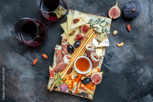 Cheese platter. Assorted cheese, wine ham, fruit, bread sticks, nuts. banner, menu, recipe place for text, top view