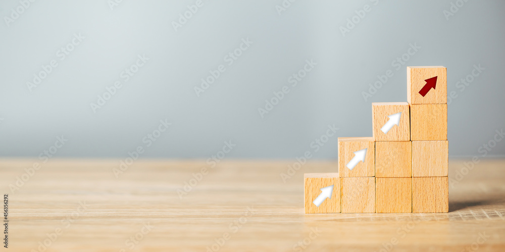 Arranging wood block stacking as step stair with arrow up.Ladder career path for business growth success process concept. Arranging wood block stacking as step stair with arrow up.Ladder career path for business growth success process concept.