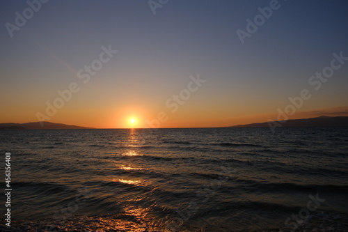Summer and holiday photo on sea during sunset and magnificent sunlight reflection on the water with its reflection on sky