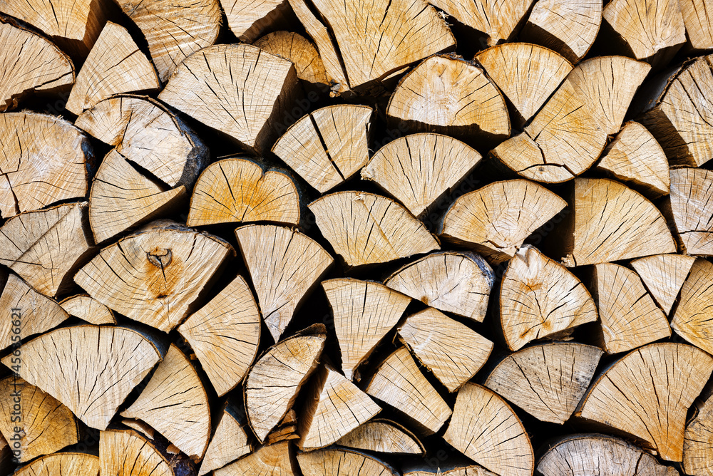 Stacked chopped wood close-up texture. Firewood storage background. Stocks of wooden logs. Chopping wood for a fireplace. Woodpile with firewood with visible wooden texture. Stacked chopped wood close-up texture. Firewood storage background. Stocks of wooden logs. Chopping wood for a fireplace. Woodpile with firewood with visible wooden texture.