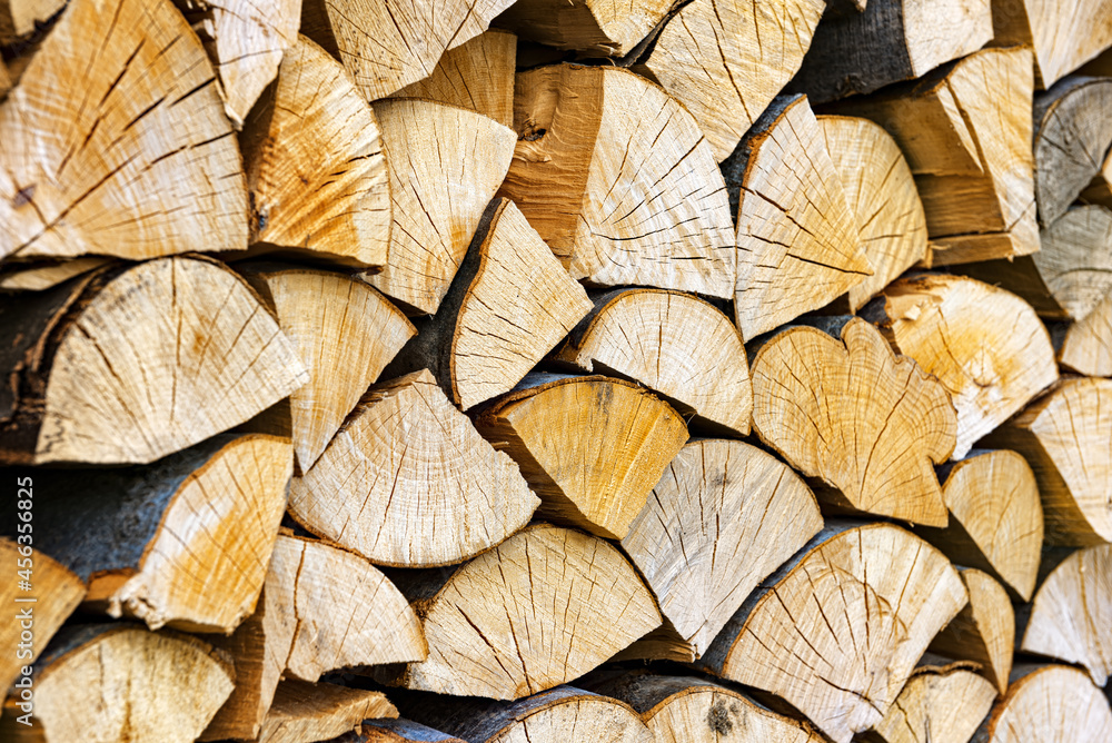 Stacked chopped wood close-up texture. Firewood storage background. Stocks of wooden logs. Chopping wood for a fireplace. Woodpile with firewood with visible wooden texture. Stacked chopped wood close-up texture. Firewood storage background. Stocks of wooden logs. Chopping wood for a fireplace. Woodpile with firewood with visible wooden texture.