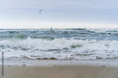 Photography Breaking waves with a kitesurfer in the background on an overcast day