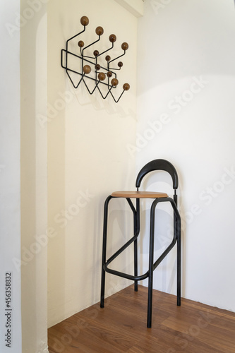 Brown seat leather chair black steel frame and cloth hanger rack on wooden floor with white wall background decoration for home architecture building contemporary.