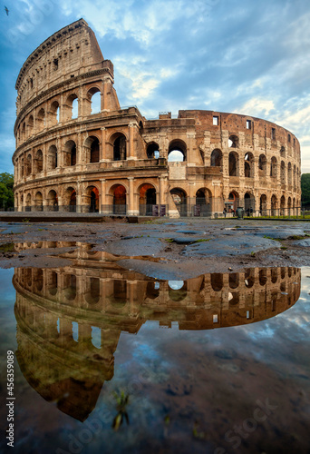 Colosseum morning in Rome, Italy. Colosseum is one of the main attractions of Rome. Coliseum is reflected in puddle. Rome architecture and landmark.