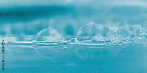 Extremely closeup of water, soap bubble on blue light effects background.