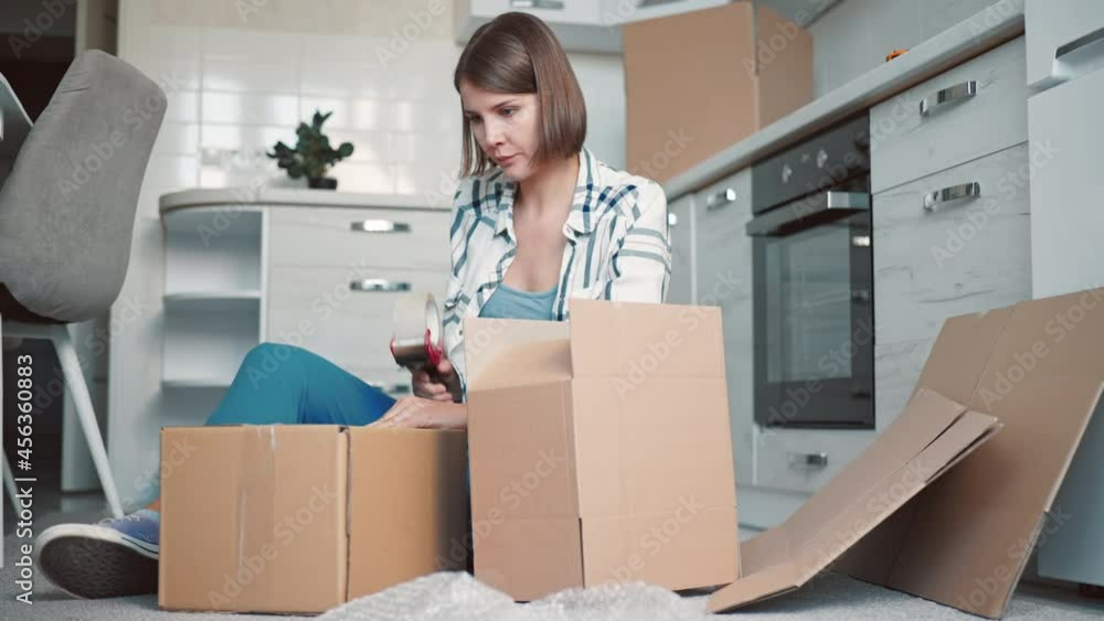 female packs dishes in kitchen female packs dishes in kitchen