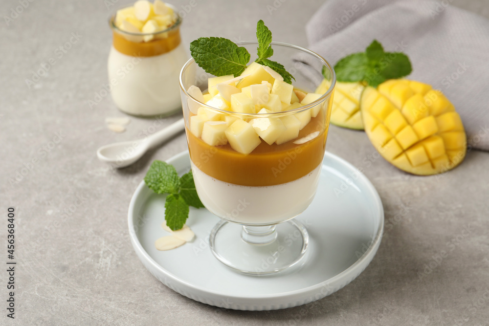 Delicious panna cotta with mango on grey table Delicious panna cotta with mango on grey table
