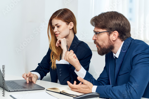 managers chatting in the office in front of a laptop officials