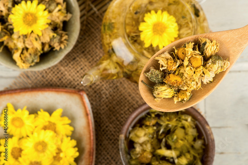 Fresh and dried chrysanthemum flowers on wood background.