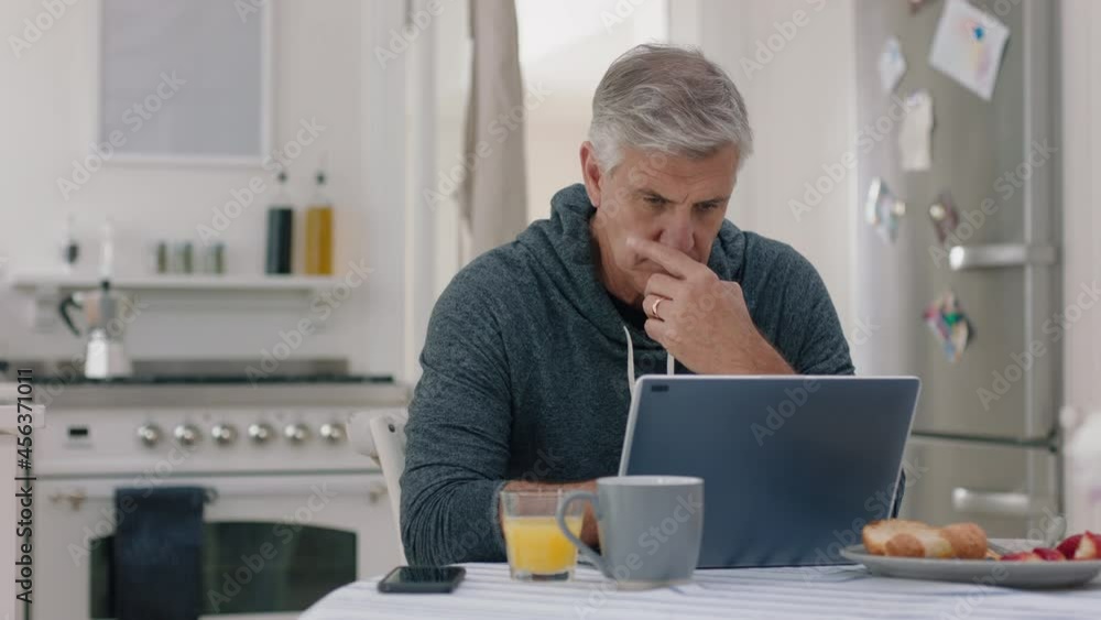 happy mature man using laptop computer at home typing messages browsing online enjoying working in morning at breakfast 4k footage happy mature man using laptop computer at home typing messages browsing online enjoying working in morning at breakfast 4k footage