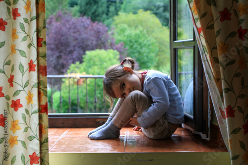 Bilde på lerret Niña posando en una ventana con bosque al fondo