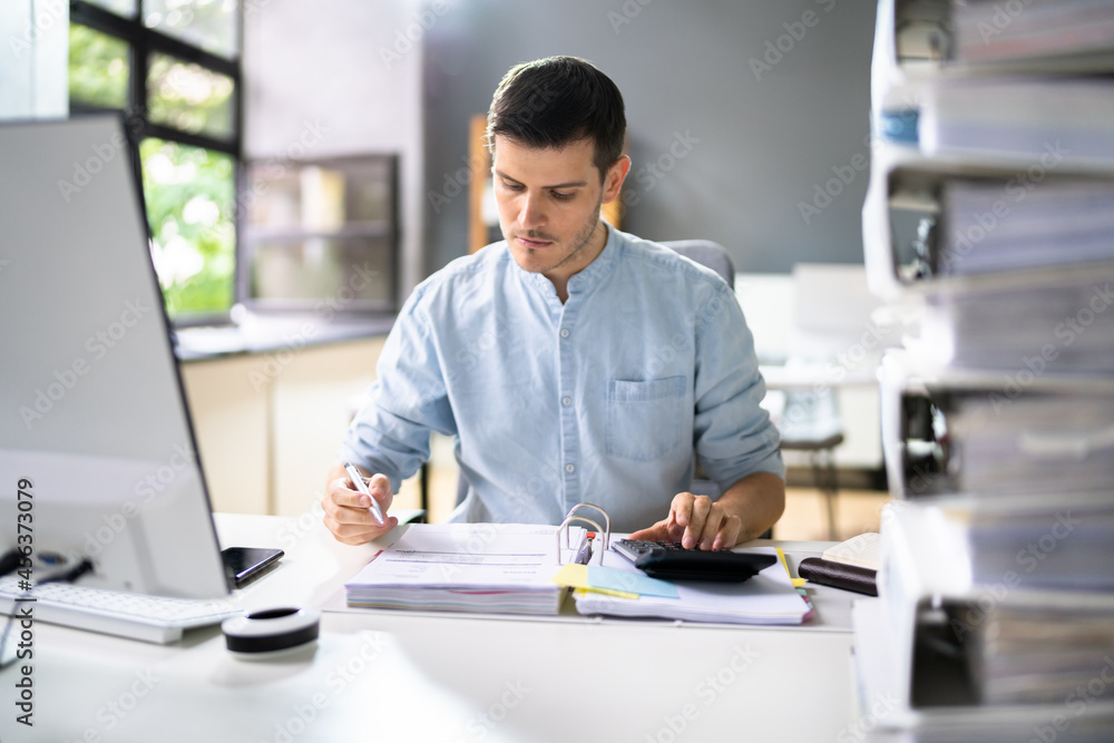 Young Businessman Working At Office With Stack Of Folders Young Businessman Working At Office With Stack Of Folders