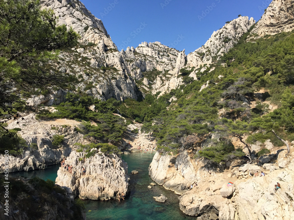 View of the Calanque de Sugiton with the Belvédère de Sugiton panoramic viewpoint in the top center, seen from the footpath descending to the calanque, in Marseille, France.