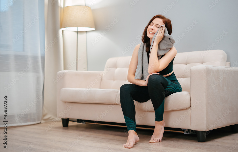 Fitness a girl who does sports is happy sitting at home on the couch resting after weight loss classes. Fitness a girl who does sports is happy sitting at home on the couch resting after weight loss classes.