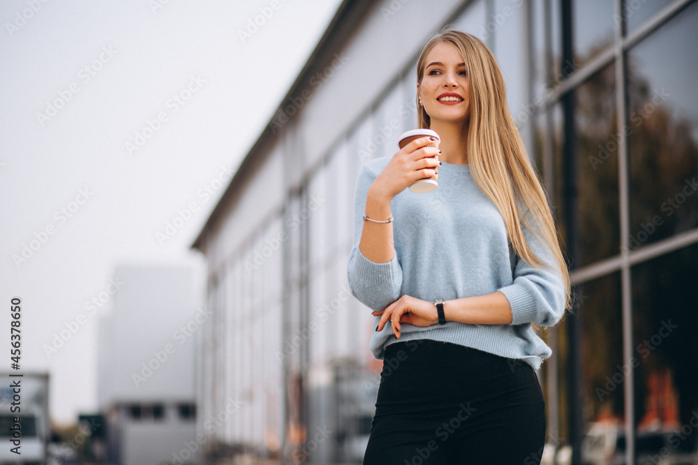 Young woman drinking coffee by the cafe