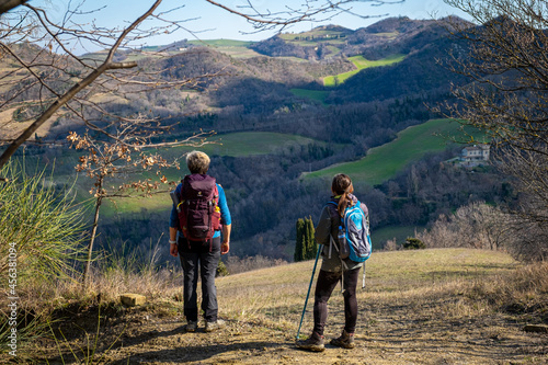 Two women with backpack admiring the apennines. Modigliana, Forlì, Emilia Romagna, Italy, Europe.