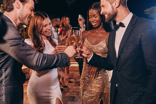 Fotografie Group of people in formalwear toasting with champagne and smiling while spending