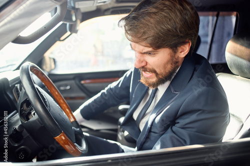 bearded man in a suit in a car a trip to work rich