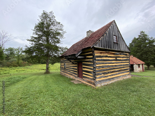 Bilde på lerret Traditional old wooden house on the grassy field in the woods in the rural area