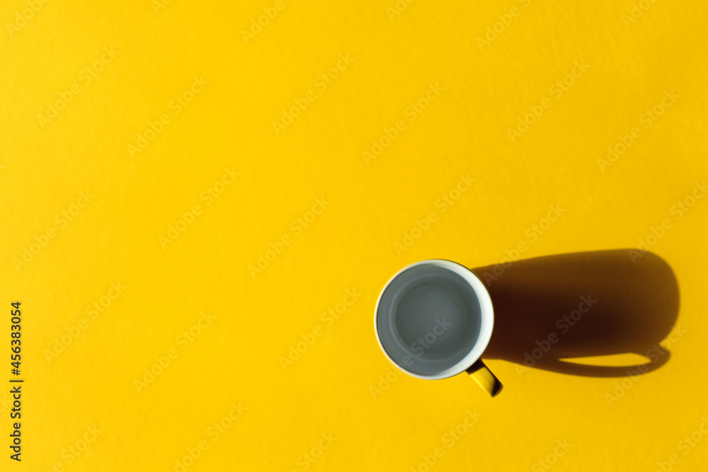 Yellow cup on yellow background. Minimalistic background.