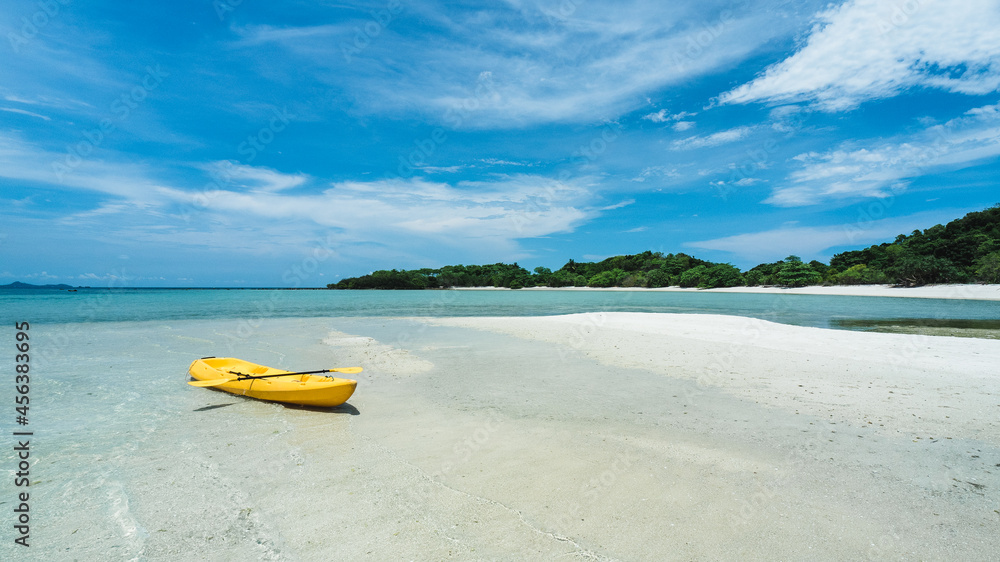 Koh Mat Sum Island, Near Koh Samui, Thailand. Yellow kayak on white sand beach with crystal clear water of tropical island in summer blue sky. Background with copy space. Koh Mat Sum Island, Near Koh Samui, Thailand. Yellow kayak on white sand beach with crystal clear water of tropical island in summer blue sky. Background with copy space.