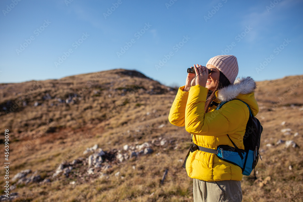 Female hiker using binocular to admire view