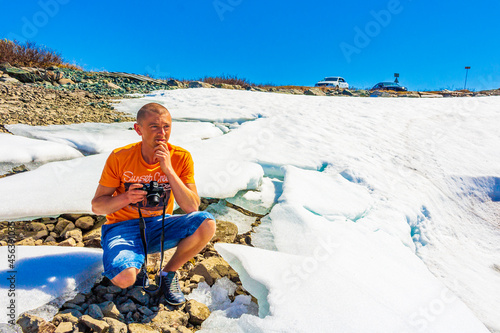 Traveler tourist at frozen turquoise lake Vavatn panorama Hemsedal Norway. photo