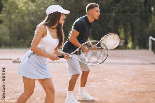 Young couple playing tennis at the court © Petro