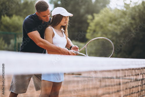 Young couple playing tennis at the court © Petro