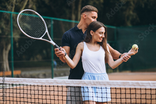 Young couple playing tennis at the court