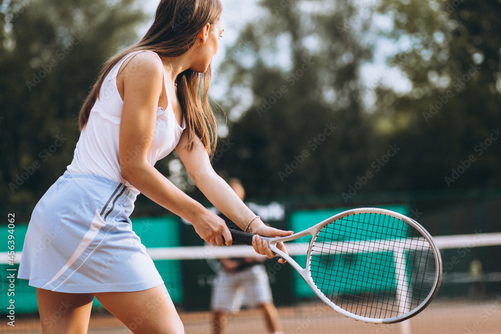 Young woman playing tennis at the court