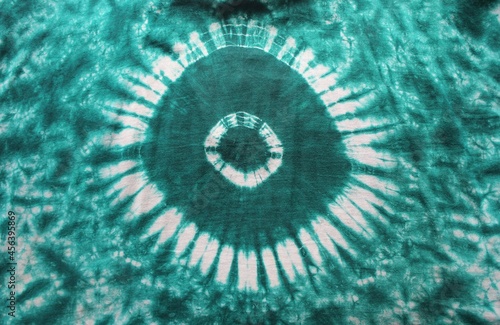 Tie dye green background with half circle layers of dye pattern fading from green to white dye fabric textile photo