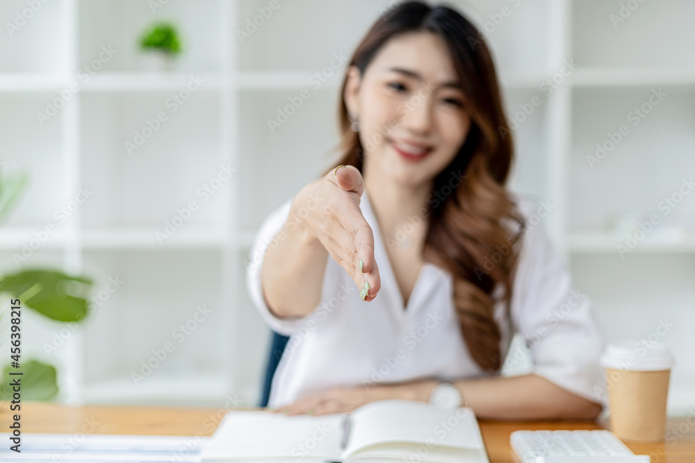 Asian women extend their hands as if asking for a handshake, a businesswoman extends her hand forward to shake a business partner, a handshake to congratulate or pay respects after a business talk. Asian women extend their hands as if asking for a handshake, a businesswoman extends her hand forward to shake a business partner, a handshake to congratulate or pay respects after a business talk.