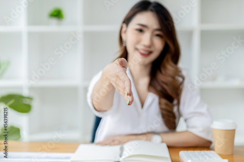 Photography Asian women extend their hands as if asking for a handshake, a businesswoman extends her hand forward to shake a business partner, a handshake to congratulate or pay respects after a business talk