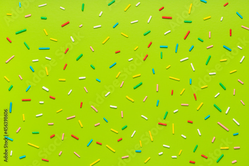 trendy pattern of colorful sprinkles for background of design banner, poster, flyer, card, postcard, cover, brochure over green