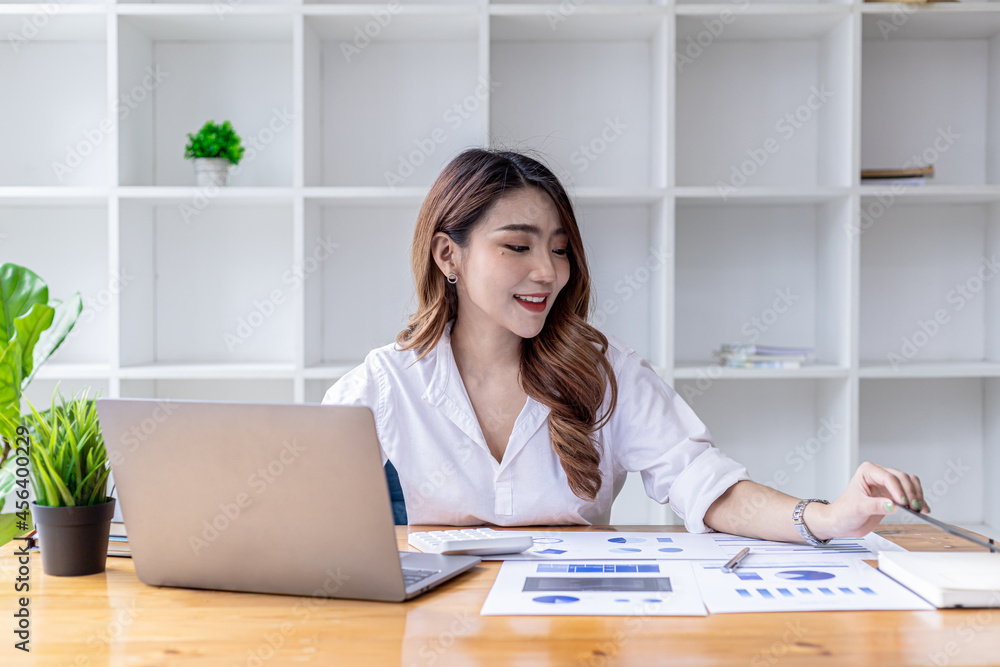 A beautiful Asian woman sits in her office, an Asian businesswoman checking the financial documents of a company she and her partner set up. Concept of company financial management. A beautiful Asian woman sits in her office, an Asian businesswoman checking the financial documents of a company she and her partner set up. Concept of company financial management.