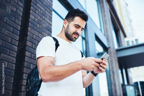 Young male travel blogger browsing website on cellphone device using 4g wireless for checking GPS on location application, millennial hipster guy reading received message during mobile mailing © BullRun